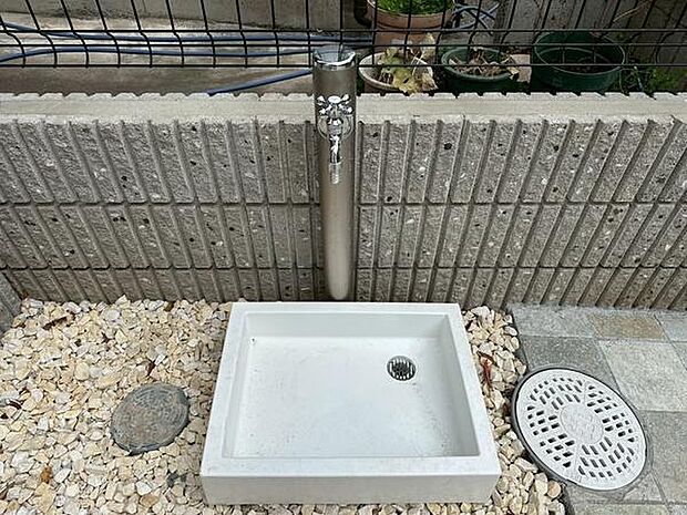 スタイリッシュな立水栓が設置されています。シンプルなデザインで外観をすっきりと見せています。排水口も付いており水はけの良さが伺えます。周囲は石材とタイルで囲まれており清潔感があります。