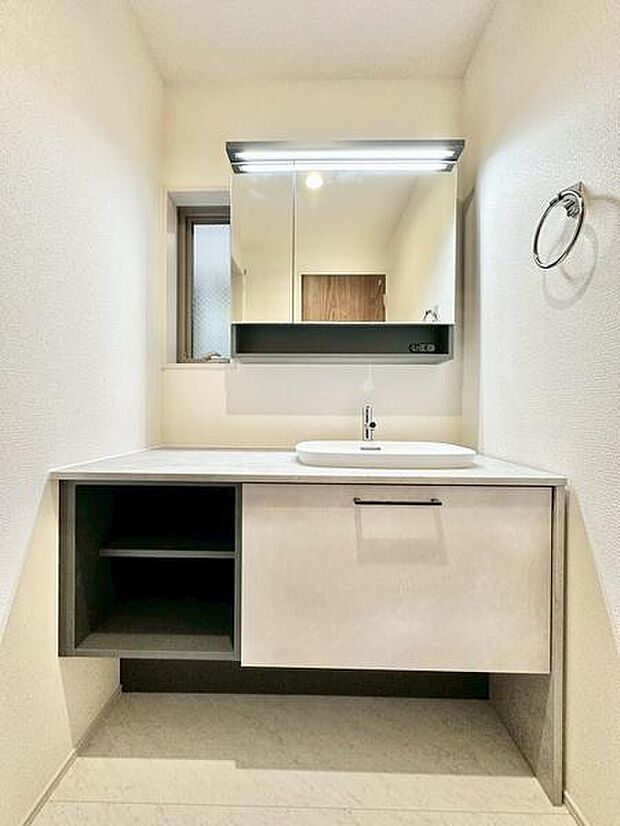 シンプルで統一感のある洗面台・洗面所は、すっきりとした印象。鏡の上下に照明が備わり明るく、収納スペースも充実した実用的な仕様です。