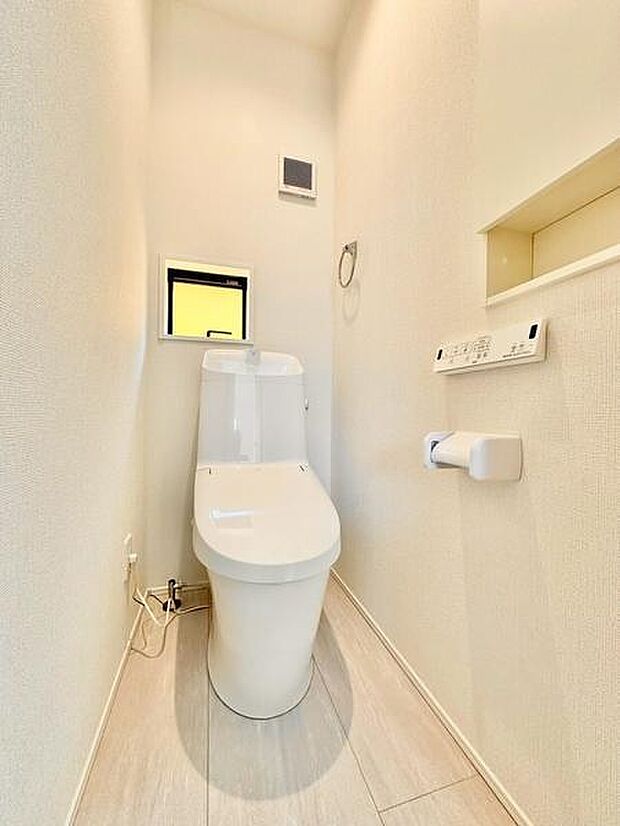 白でまとめた明るいトイレにニッチを配置し、インテリアを飾ることで空間にさりげないアクセントを加えています。