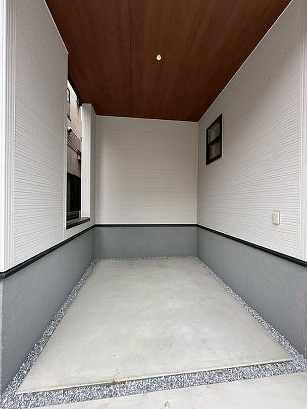屋根付きの駐車場なので天候に左右されにくい利便性があります。コンクリート仕上げでお手入れも簡単です。壁や天井も落ち着いた色合いで統一されています。縁取りの砂利部分が清潔感を演出しています。