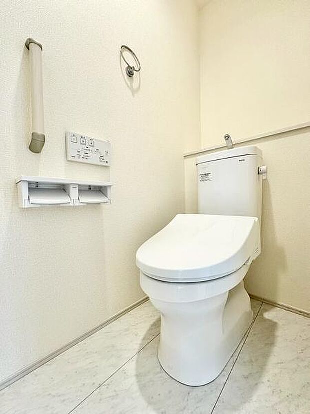 トイレットペーパーホルダーは2連仕様でストック切れの心配を軽減。さらに手すりを設置し、幅広い世代に配慮した安心のトイレ空間です。