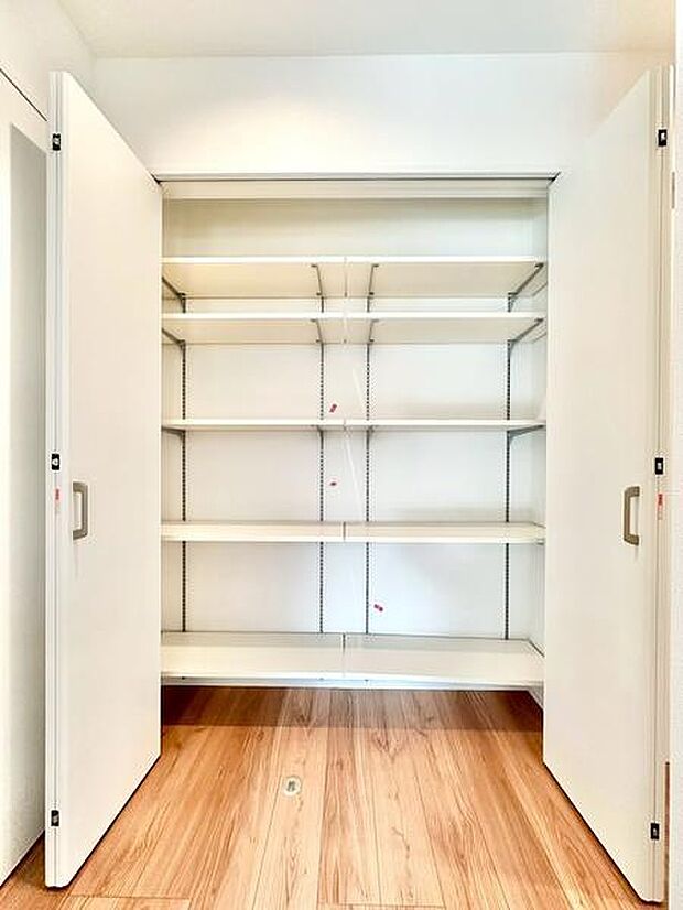 大きく開く両開き扉が特徴の収納スペースです。シンプルな可動棚が複数設けられており整理整頓に便利です。明るい室内の雰囲気に調和したデザインです。棚板の高さ調整が可能で用途に合わせやすい造りです。