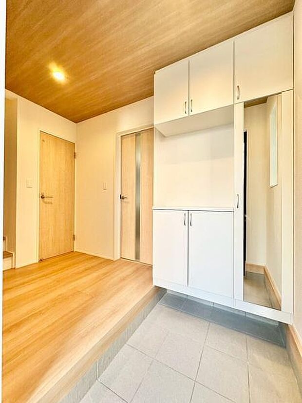 明るいウッドと白を基調としたシンプルなデザインの玄関。収納棚があり、靴や小物をすっきり整理できるため、清潔感のある空間を保てます。