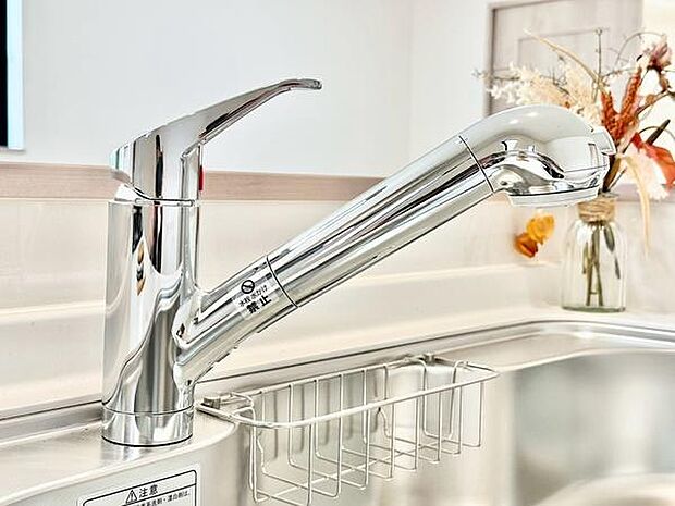 シンプルなデザインの水栓がキッチンをすっきりとした印象に。手元で操作しやすいレバーを備え、使い勝手にも配慮されています。収納バスケットも付いており、調理小物などの整理に便利です。