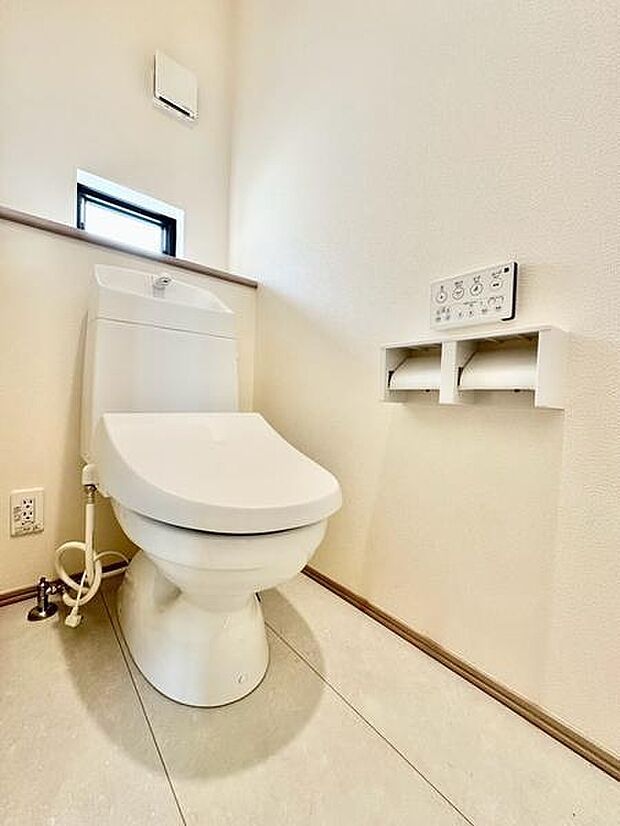 窓付きで換気がしやすく、明るく清潔感のあるトイレです。温水洗浄便座を備え、便利な二連ペーパーホルダーも設置。壁リモコンでウォシュレット機能などを操作できます。