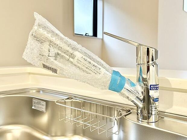 シンプルなデザインのキッチン水栓が設置されています。ステンレス製のシンクが清潔感を演出します。