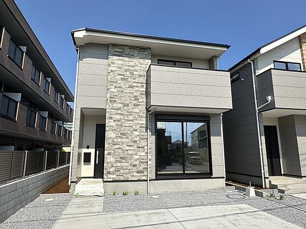 シンプルで洗練された外観デザインが特徴の戸建住宅です。アクセントの石材が建物全体に上質な印象を与えています。大きな窓からはたっぷりと自然光が入ります。建物周囲には余裕のあるスペースが確保されています。