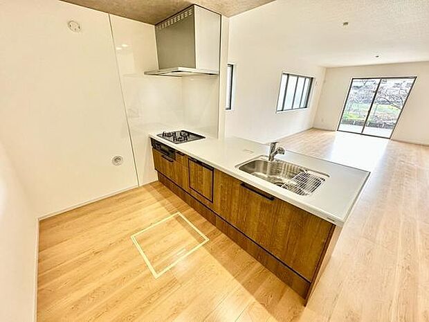 木目調のペニンシュラキッチンが空間にあたたかみを添える、開放感あふれるデザイン。リビングとゆるやかにつながり、家族との会話も自然と広がります。