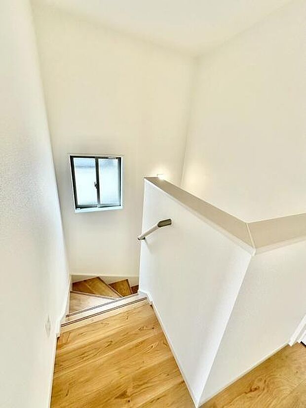 採光用の小窓から光が差し込む明るい階段。手すり付きで、ご家族みんなが安心して使える設計です。