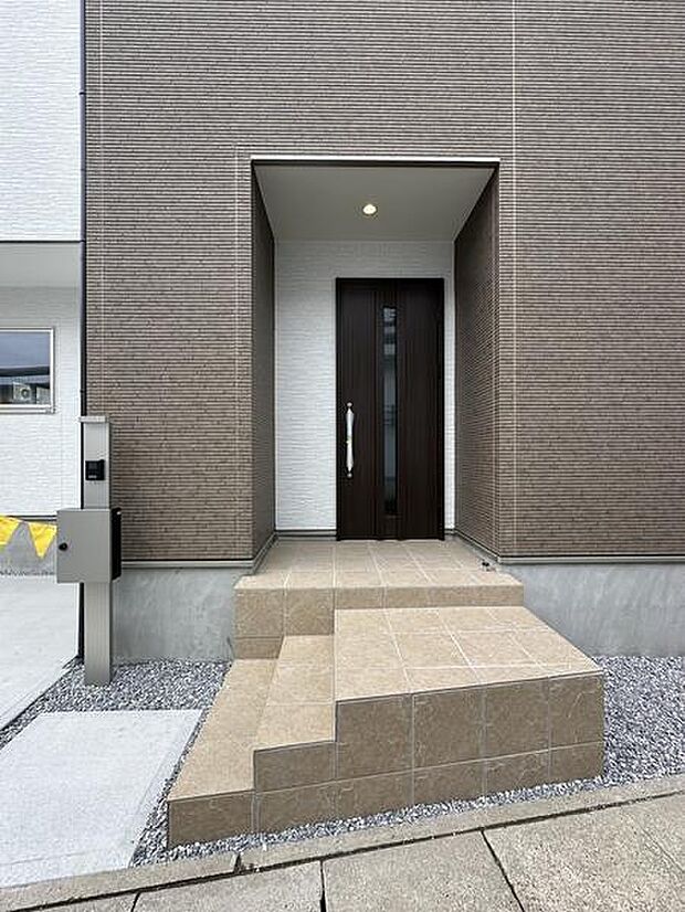 玄関は屋根付きの設計で雨の日でも安心して出入りできます。徒歩圏内に商業施設が充実しており、毎日のお買い物にも便利です。