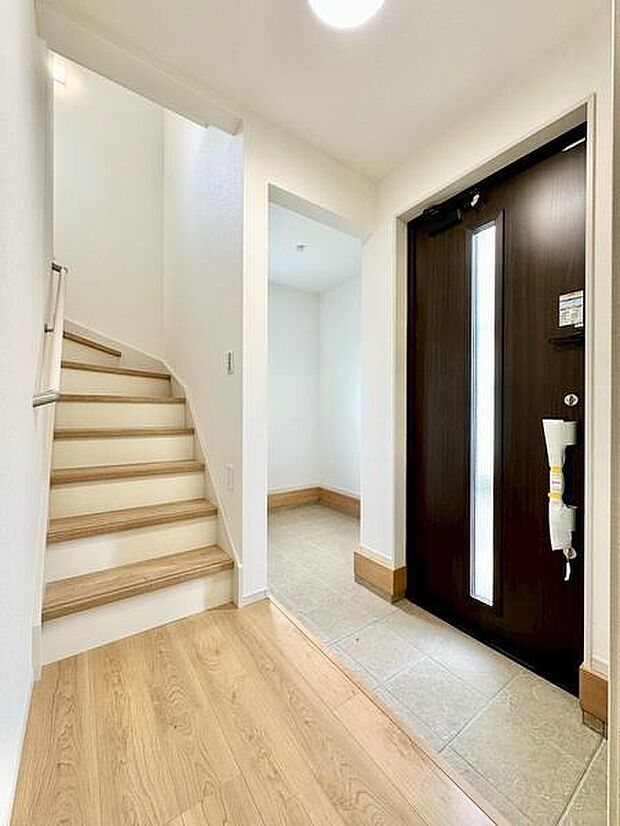 明るい玄関スペースが印象的です。木目調のドアやフローリングが調和して落ち着いた雰囲気です。シューズ収納スペースも確保されており使い勝手に配慮されています。ゆとりある玄関ホールが来客時にも便利です。