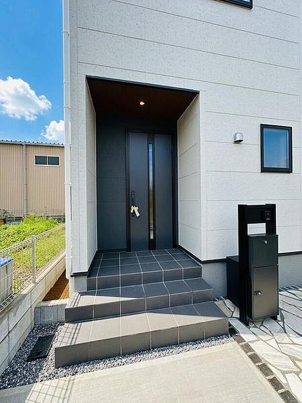 玄関まわりは壁に囲まれたつくりで、雨の日も雨が直接入り込みにくいのがポイント。傘を開いたり閉じたりする際にも、落ち着いて出入りできます。