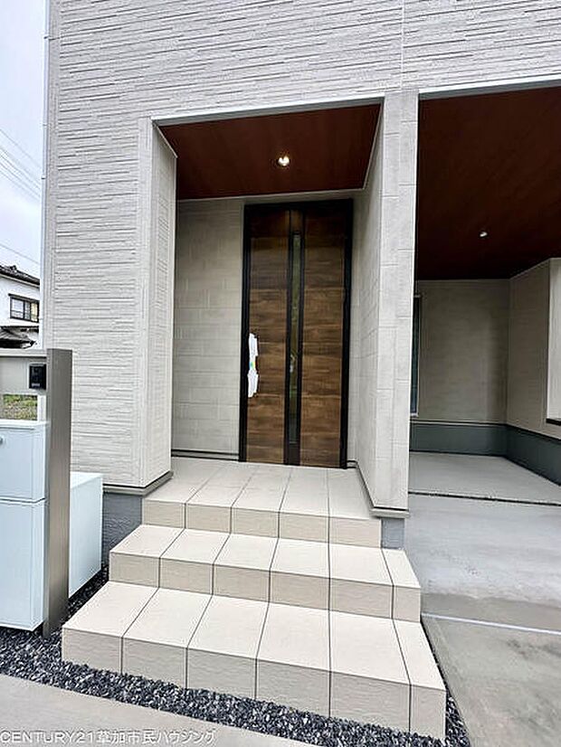 壁に囲まれた玄関スペースは、雨の日の出入りにも便利。壁際のくぼみは傘立てや小物置きとして活用でき、玄関まわりをすっきり整えられます。