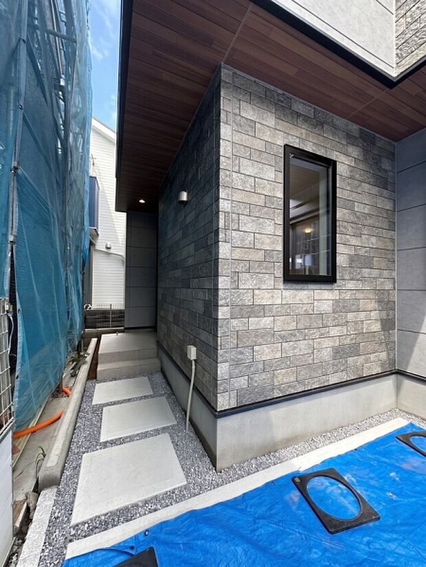 奥まったL字型のアプローチを採用し、道路から玄関までの視線が抜けにくい設計。外からの視線を自然に遮り、プライバシーにも配慮した落ち着きのある玄関まわりです。
