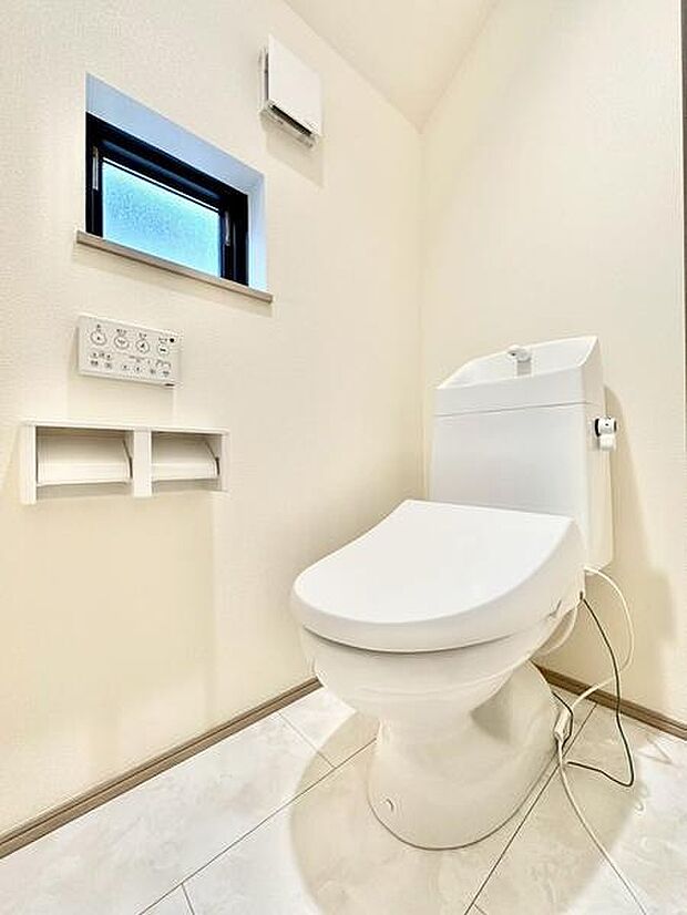 窓が設置されているため室内の換気が行いやすいトイレです。床や壁も明るい色合いで清潔感を演出しています。手洗い付きのタイプが採用されており機能面でも便利です。