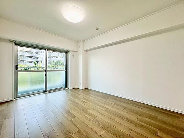大きな窓から光が差し込む、広々としたリビングです。家具配置の自由度が高い構成で、ナチュラルなフローリングが空間全体に統一感を与えています。