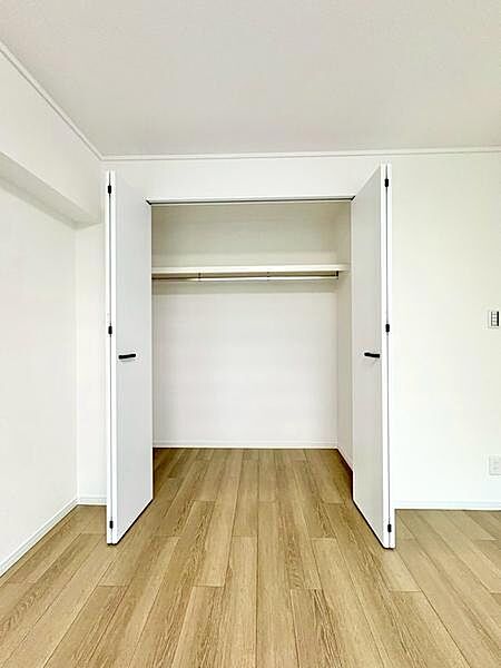 （洋室6.7帖収納）両開きの扉により開口部が広く取れ、荷物の出し入れがしやすい仕様です。天井近くまで高さがあり、収納力にも配慮された造りです。