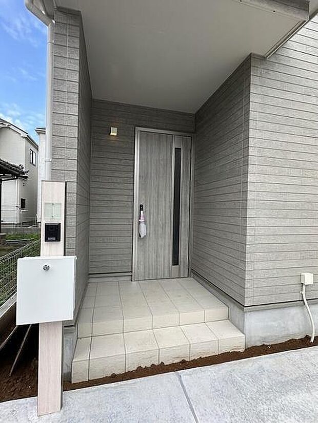 壁に囲まれた玄関スペースで、雨の日も濡れにくく快適に出入りできます。傘を差したままでも動きやすく、荷物の出し入れにも嬉しい設計です。