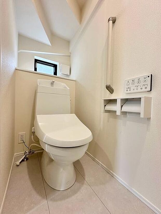 明るい白基調でまとめたトイレは、手すり付きで毎日の使いやすさにも配慮。窓を設けており、自然光が入る明るくすっきりとした空間です。