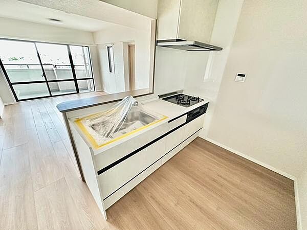 白を基調としたシンプルで上品なシステムキッチン。明るく清潔感のある空間で、快適な家事時間を実現します。家族の様子を見ながら料理ができる対面式で、毎日の団らんを楽しめるキッチンスペースです。