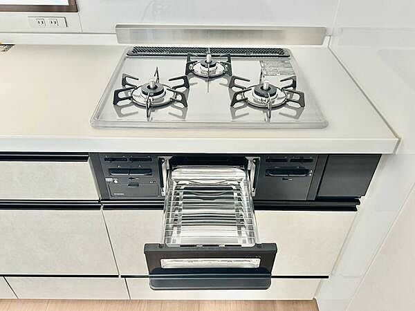 三口コンロを備えた使い勝手の良いキッチン。朝食の準備や夕食のおかず作りなど、複数の料理を同時に進められ、毎日の調理時間を快適にサポートします。魚焼きグリルも搭載され、焼き料理など料理の幅も広がります。