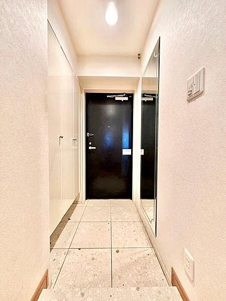 ゆとりを感じさせる奥行のある玄関。タイル床が空間のアクセントとなり、落ち着いた雰囲気に仕上がっています。