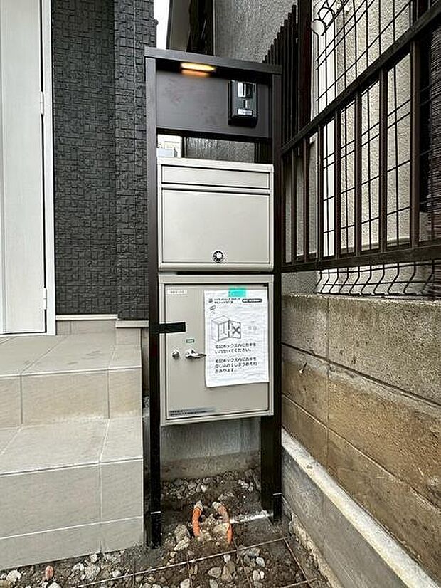 門柱一体型の宅配ボックスが設置されており荷物の受け取りが便利です。インターホンやポストも一体化されており機能的な外構です。玄関前に配置されているため移動もスムーズです。