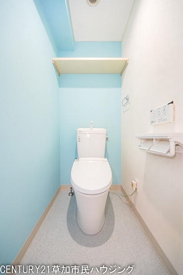 温水洗浄機能付きトイレ。淡いブルーのクロスが爽やかな印象を与えてくれます