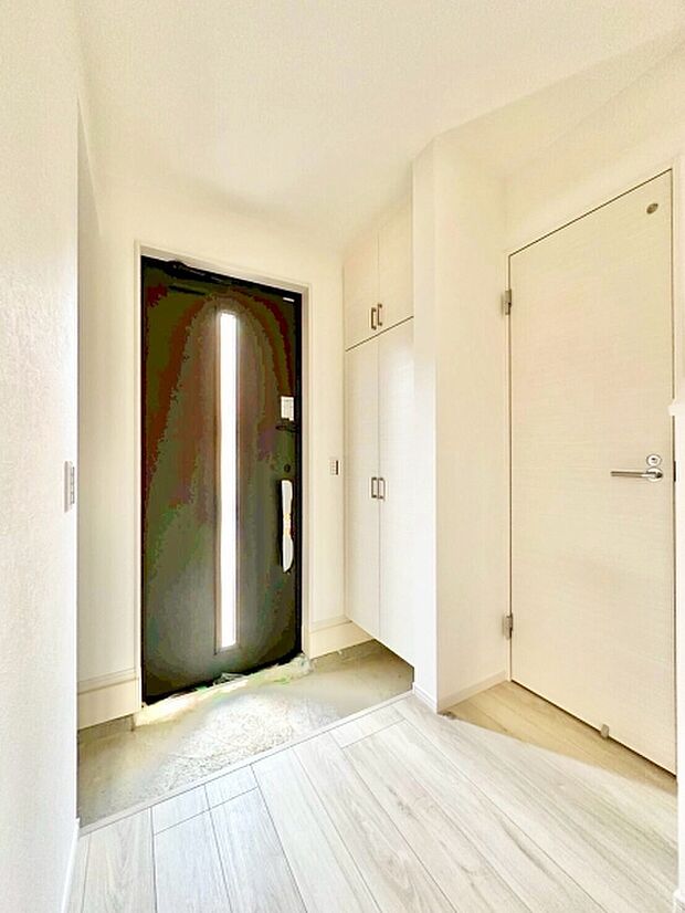 明るい玄関です。収納スペースが豊富ですっきりとした印象です。採光の工夫が施されており清潔感があります。床の色合いが落ち着いており玄関全体を引き締めています。