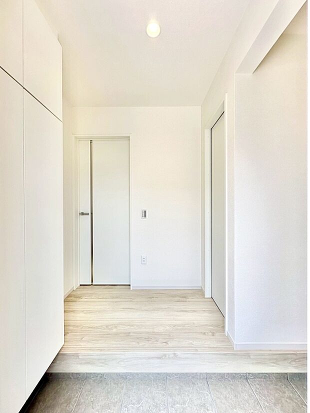 白を基調とした玄関が居住空間に明るさをもたらします。すっきりとしたデザインで清潔感があります。収納スペースも充実しており使い勝手にも配慮されています。床の切り替えがアクセントになり洗練された印象です。