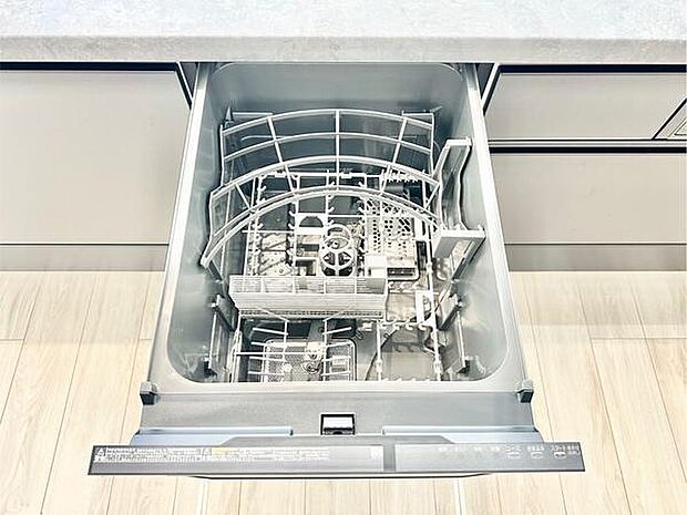 食器洗い乾燥機が備え付けられており後片付けがスムーズに進みます。キッチン周りがすっきりとした印象です。収納スペースも十分に確保されています。床やカウンターの素材感が明るく清潔感のあるキッチンです。