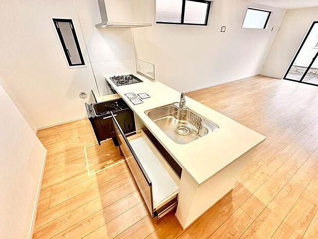 キッチンはシンプルなデザインで使い勝手の良さが感じられます。シンクやコンロが直線上に配置され動線もスムーズです。引き出し収納も備えられており整理整頓に役立ちます。明るい床材が空間を引き立てています。