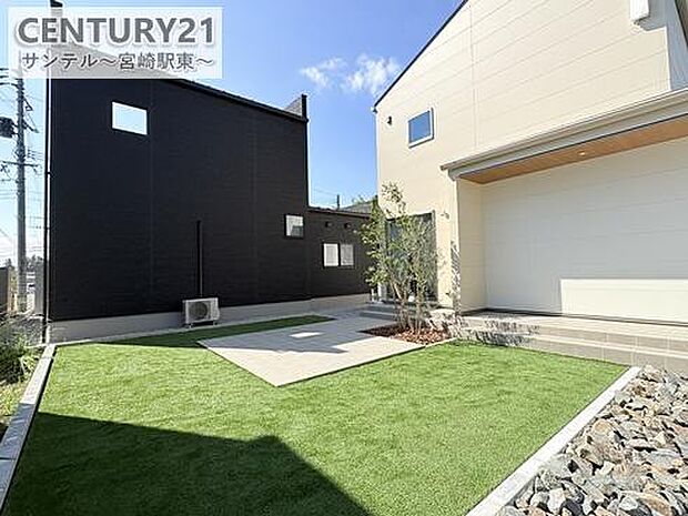 人工芝とタイルデッキのある庭は、お子様の遊び場やBBQにも最適。手入れが簡単で、年中きれいな緑を楽しめます。