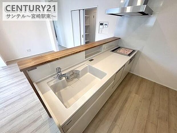 同仕様写真（キッチン）人気のカウンターキッチン。人口大理石のお手入れがしやすいキッチンです。食洗器やIHクッキングヒーターがついたシステムキッチンです。