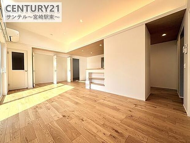 勾配天井を採用した開放的なリビング。天井が高く広がりを感じる空間設計で、窓からの光もたっぷり。家族が自然に集まる心地よいくつろぎの場所です。