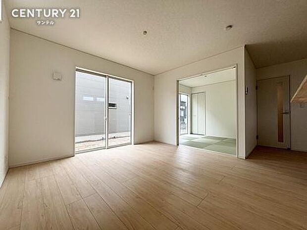 明るい木目調の床材が広がるゆとりある空間。隣接する5帖の和室の引き戸を開放すれば、さらに奥行きのある大空間として活用できます。家族みんなが自然と集まり、のびのびとリラックスできる快適なリビング。