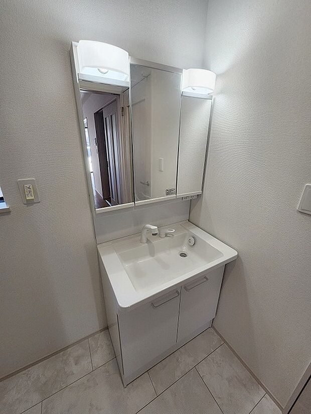三面鏡に洗面台。 コンセントに照明機能、多機能性を備えた設備です。  