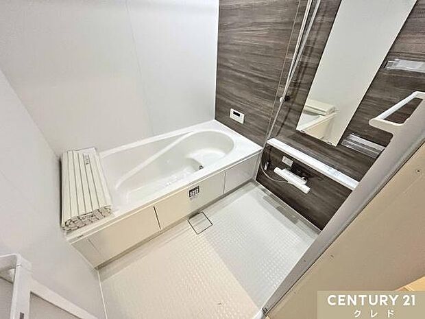 落ち着いた木目パネルの浴室。追い炊き・浴室暖房乾燥機付きで一年中快適。保温浴槽と滑りにくい床で入浴も安心です。