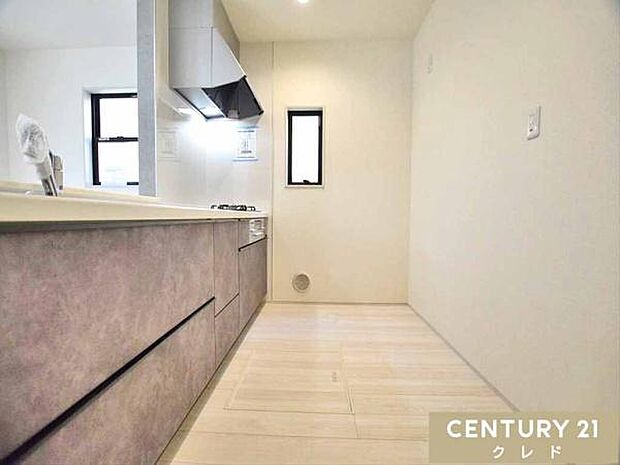 ご夫婦が料理台に並んで作業ができるゆとりあるキッチン。シンク近くの扉から洗面所・浴室へすぐで、家事効率にも配慮しています。