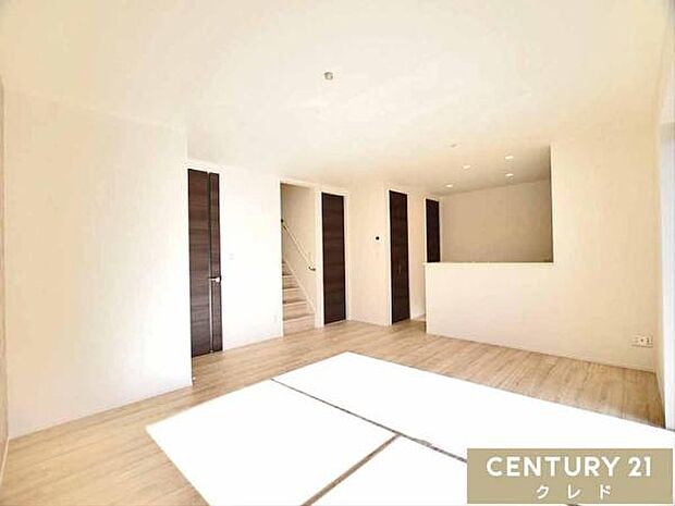 【LDK18帖】明るいフローリングと白を基調とした内装で、どんな家具とも相性の良い憩いの場。ご家族の外出・帰宅が見守れるリビング階段を採用。