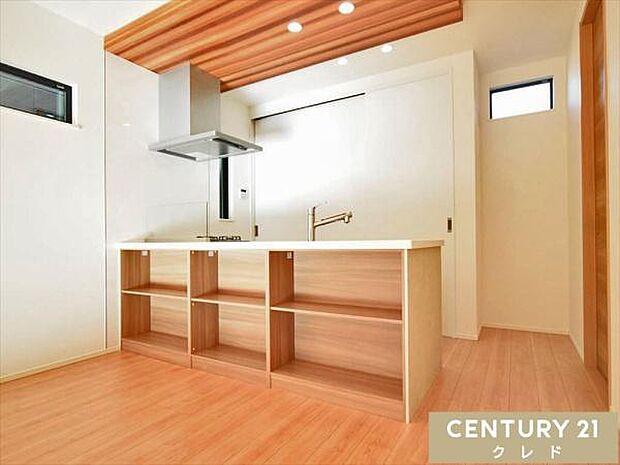 リビングとの統一感のある折下げ天井を使用したキッチン。収納部分には家族の思い出の写真や小物もディスプレイできます。