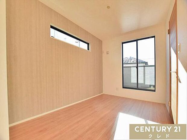 【洋室5.7帖】落ち着いた印象の木目調のクロスが安らぎの印象を与える室内は寝室にもおすすめ。バルコニーからの柔らかな日差しが室内を包み込みます。