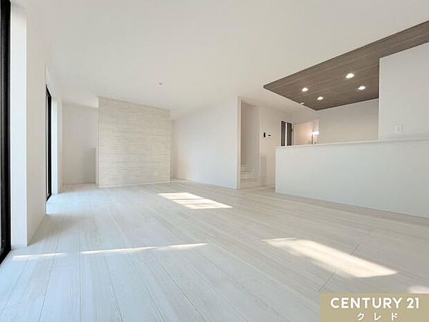 【LDK19帖】ストーン調のアクセントクロスやキッチン折り下げ天井の木の風合いがマッチした、ゆとりの19帖のリビング。テーブルやソファなどを、動線を確保した配置が可能。