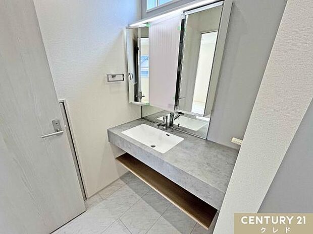 大理石調カウンターが映えるオープンサニタリー。広々とした洗面スペースと大型ミラーを採用し、ホテルライクな高級感を演出します。