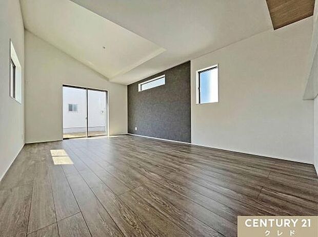 【LDK18帖】開放的な勾配天井と、シックなグレーのアクセントクロスが織りなすスタイリッシュな18帖のLDK。洗練されたモダンなデザインで、毎日の暮らしを彩ります。