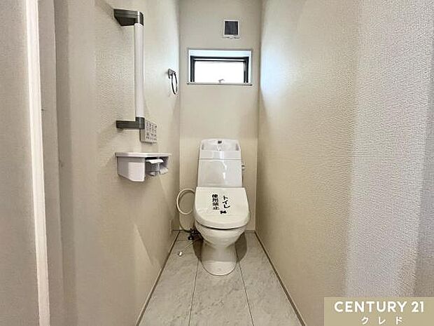 見やすく操作が簡単な温水洗浄便座。壁面にリモコンを設置することにより、楽な姿勢での操作が可能。来客時や家族全員が使用する1階のトイレには立ち座りなどをサポートする手すりを備え付けました。