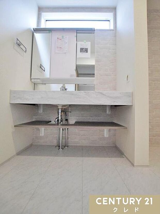 大理石調カウンターが映えるオープンサニタリー。広々とした洗面スペースと大型ミラーを採用し、ホテルライクな高級感を演出します。