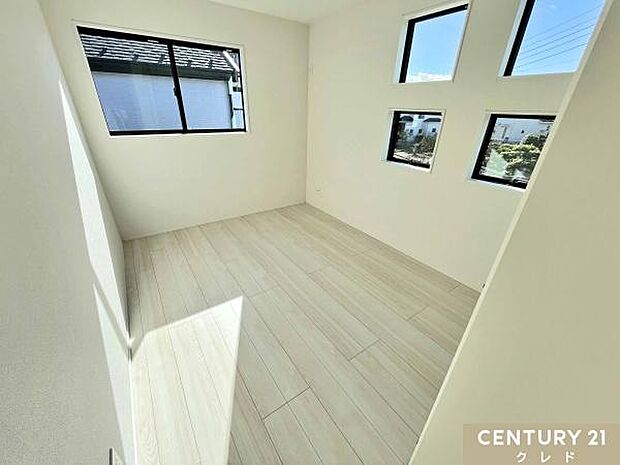 【洋室6.5帖】白を基調とした清潔感のある内装。4つの小窓がデザインのアクセントになっており、日当たりも良好です。