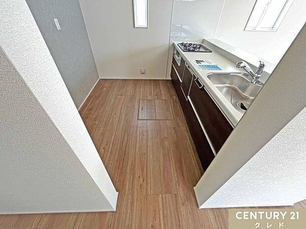 アクセントクロスにもこだわったキッチンスペース。ゆとりを持たせており、カップボードや冷蔵庫を置いてもすれ違いやすく、ご夫婦での調理もスムーズ。