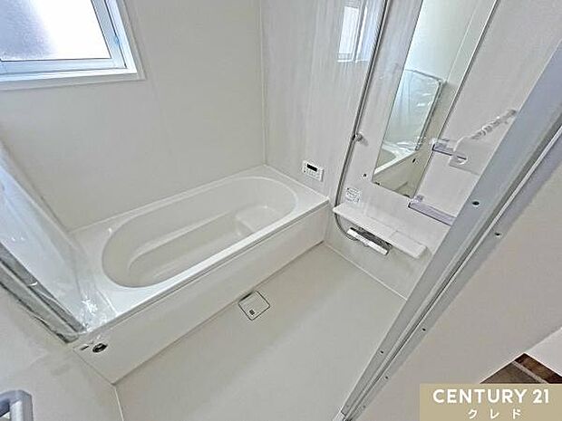 浴室乾燥機と浴室物干しが設置された充実設備の浴室です。ベンチタイプの浴槽はくつろぎの入浴を楽しめ、快適さと便利さを兼ね備えています。